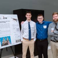 Students posing in front of their project